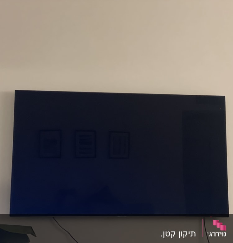 טלוויזיה תלויה על הקיר עם כבל חשמל